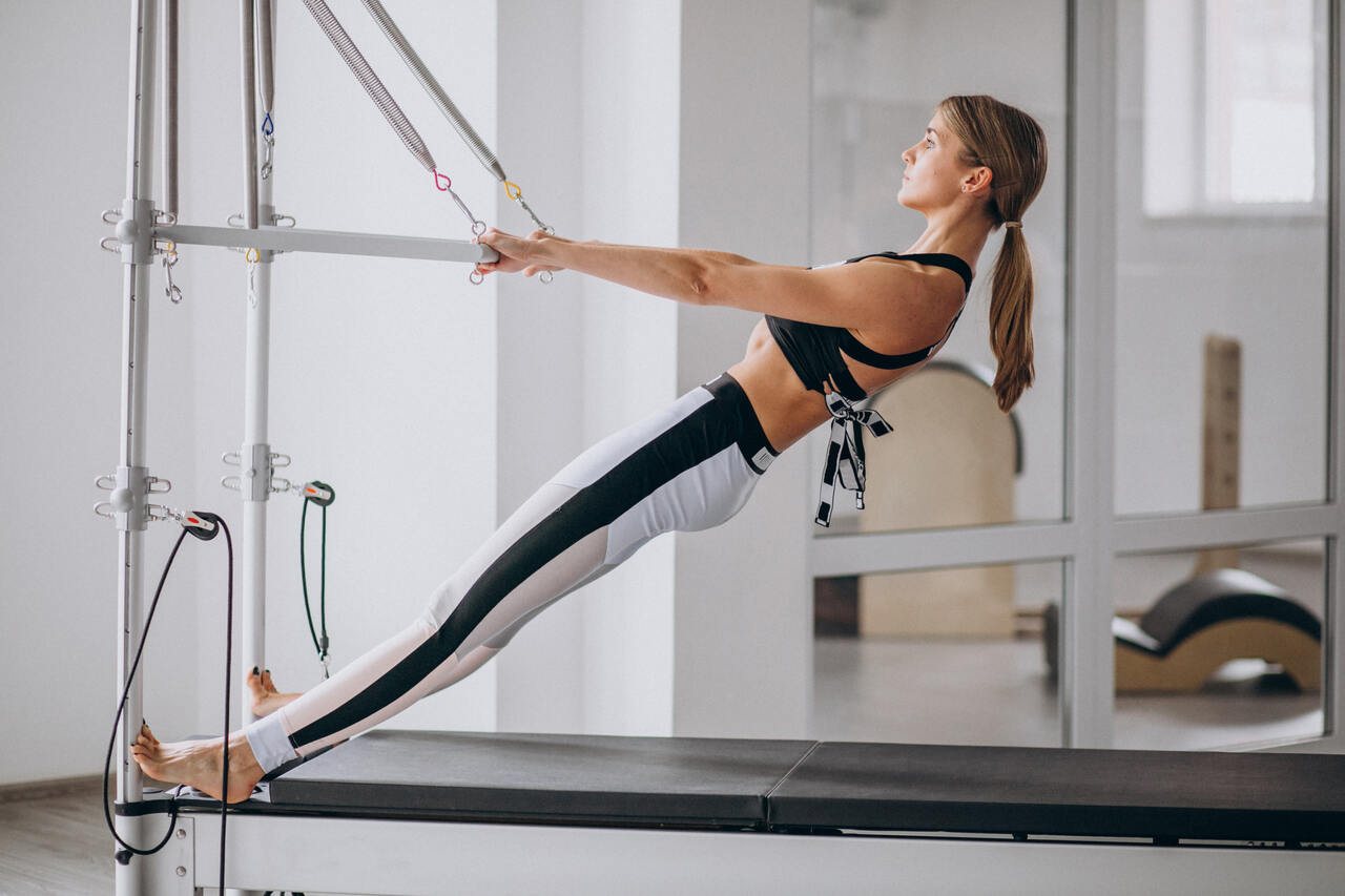 woman-practising-pilates-pilates-reformer_Easy-Resize.com